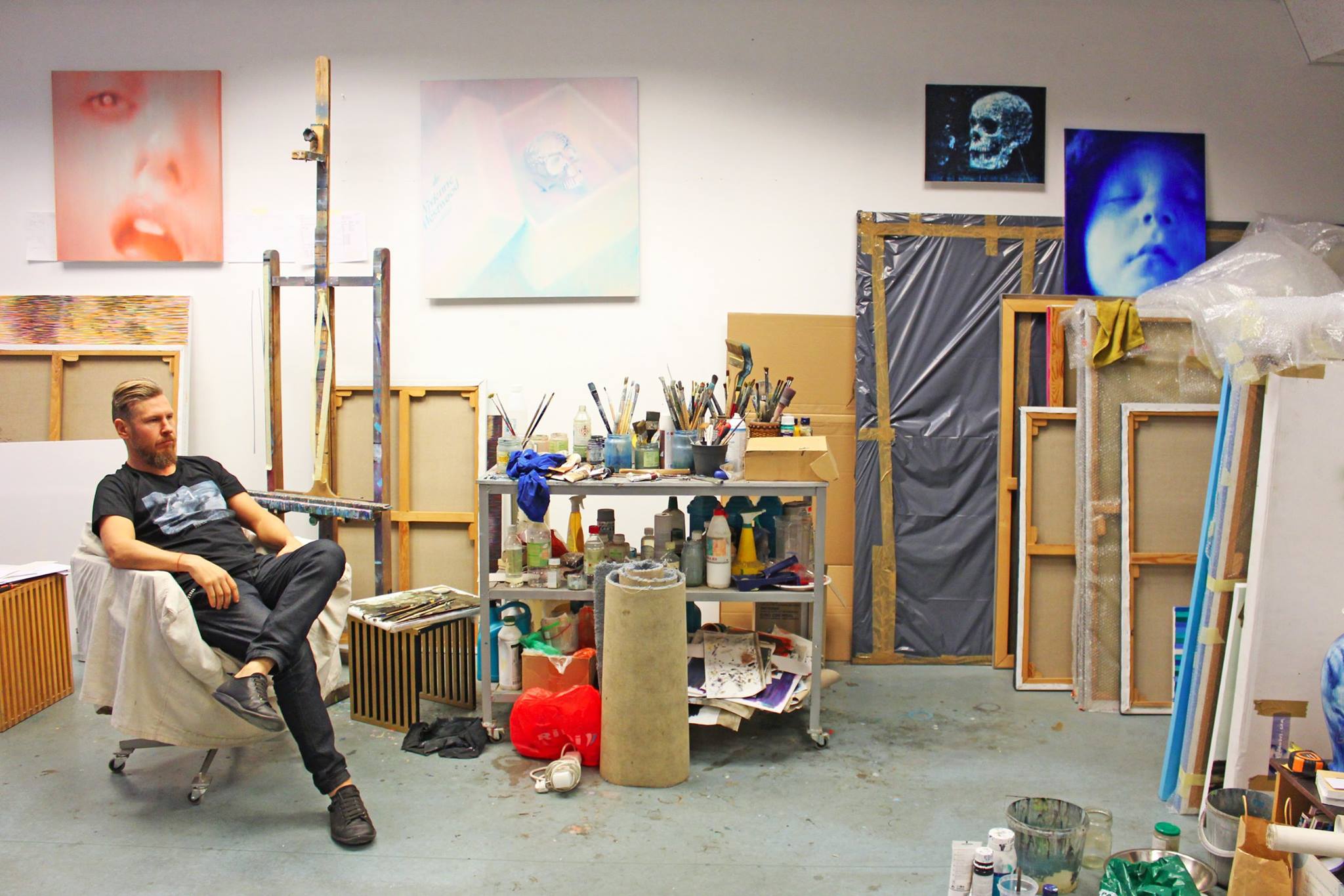 Ritums relaxing in his studio wearing the Tshirt in support of the future art museum